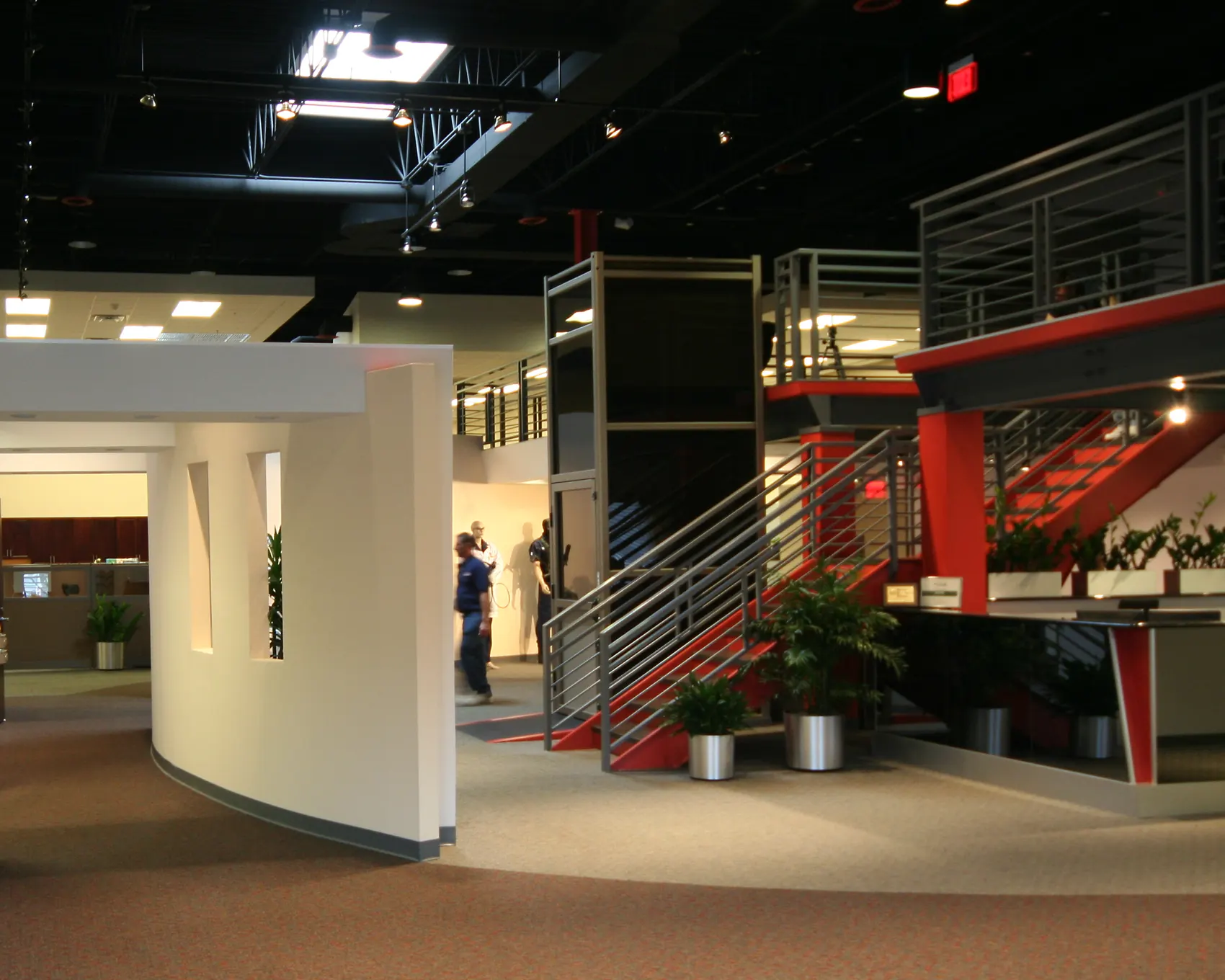 Open office with a curved mezzanine and red accents